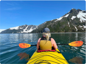 Aya clinician on a kayak with mountainous background